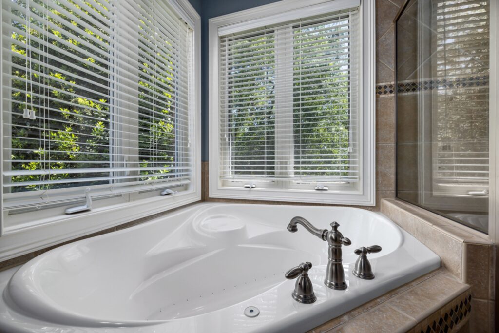 Luxury corner bathtub with window views.