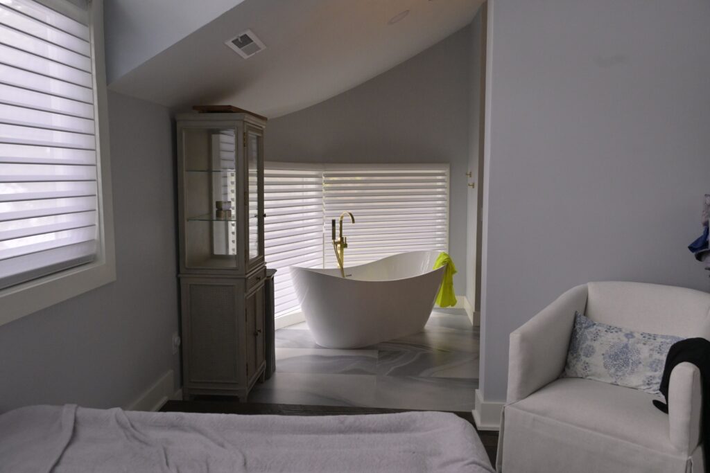 Modern bathroom with freestanding tub and blinds.