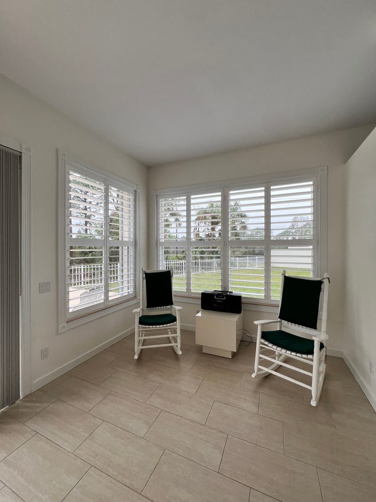 Bright sunroom with chairs and windows.