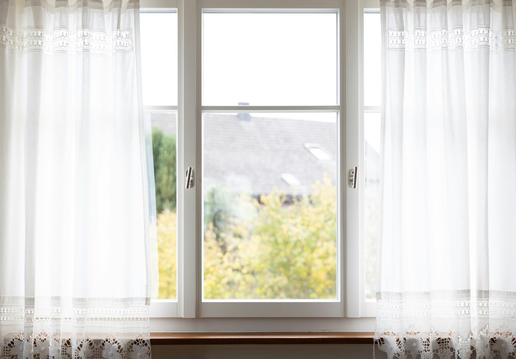 Window view with white curtains and garden